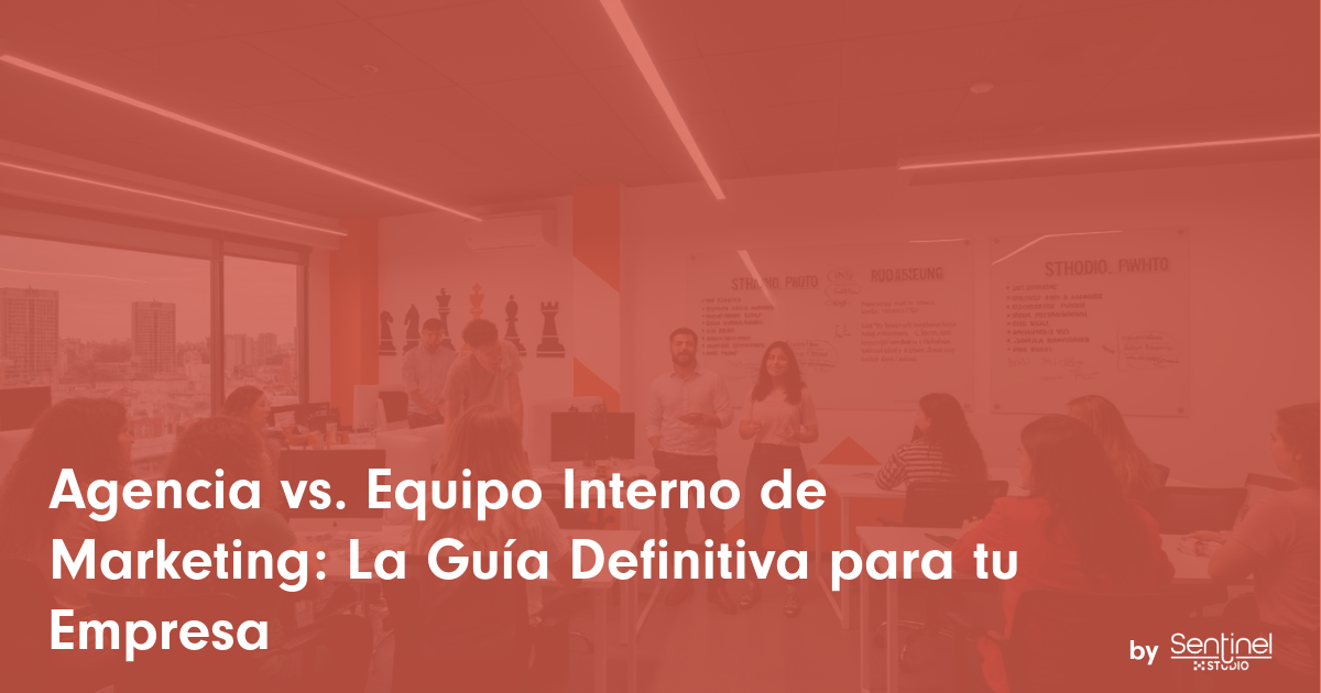 Una oficina moderna con gente hablando en pequeños grupos. Se ven grandes carteles y vistas de la ciudad. Un texto blanco en español dice: "Agencia vs equipo interno de marketing: La Guía Definitiva para tu Empresa". El logotipo de Sentinel Studio está abajo a la derecha.