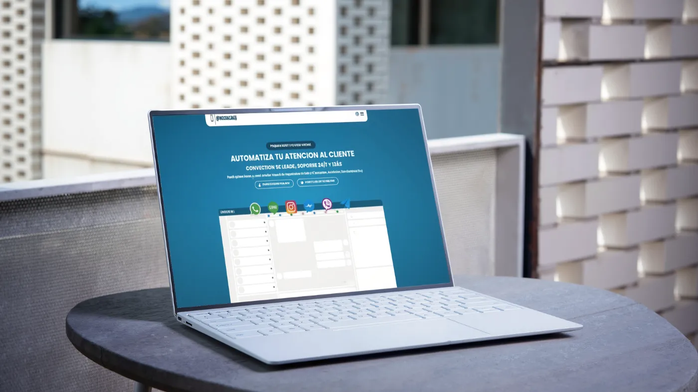 Un portátil blanco sobre una mesa al aire libre muestra el sitio web Plis Chat Me para automatizar la atención al cliente en español.