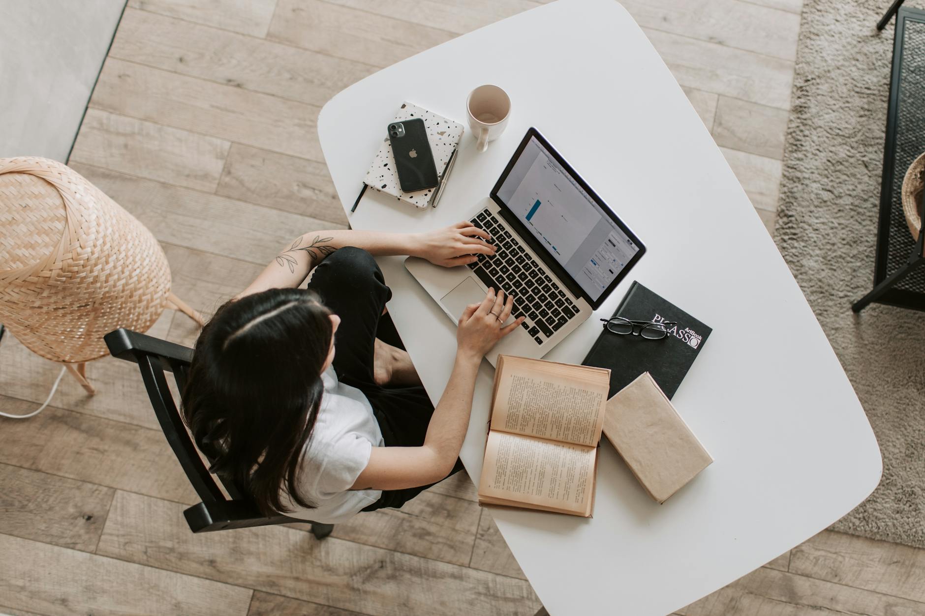 Young lady typing on keyboard of laptop in living room keywords