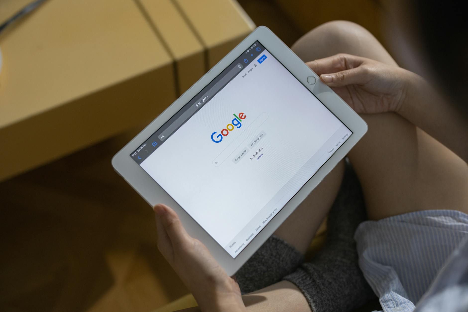 A person holding white ipad mini